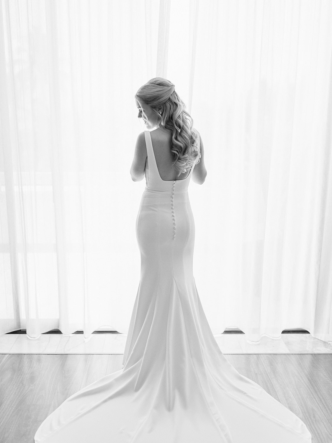 Bride standing in front of sheer curtain wearing her wedding dress on Hayman Island