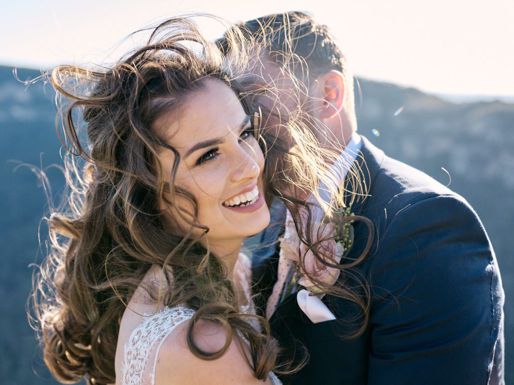 Close up of bride and groom laughing with wind blown hair