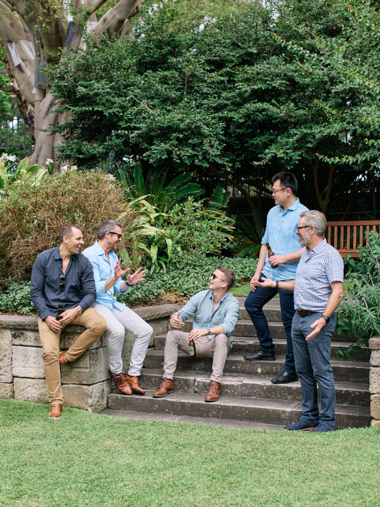 Group of men sitting on stairs talking
