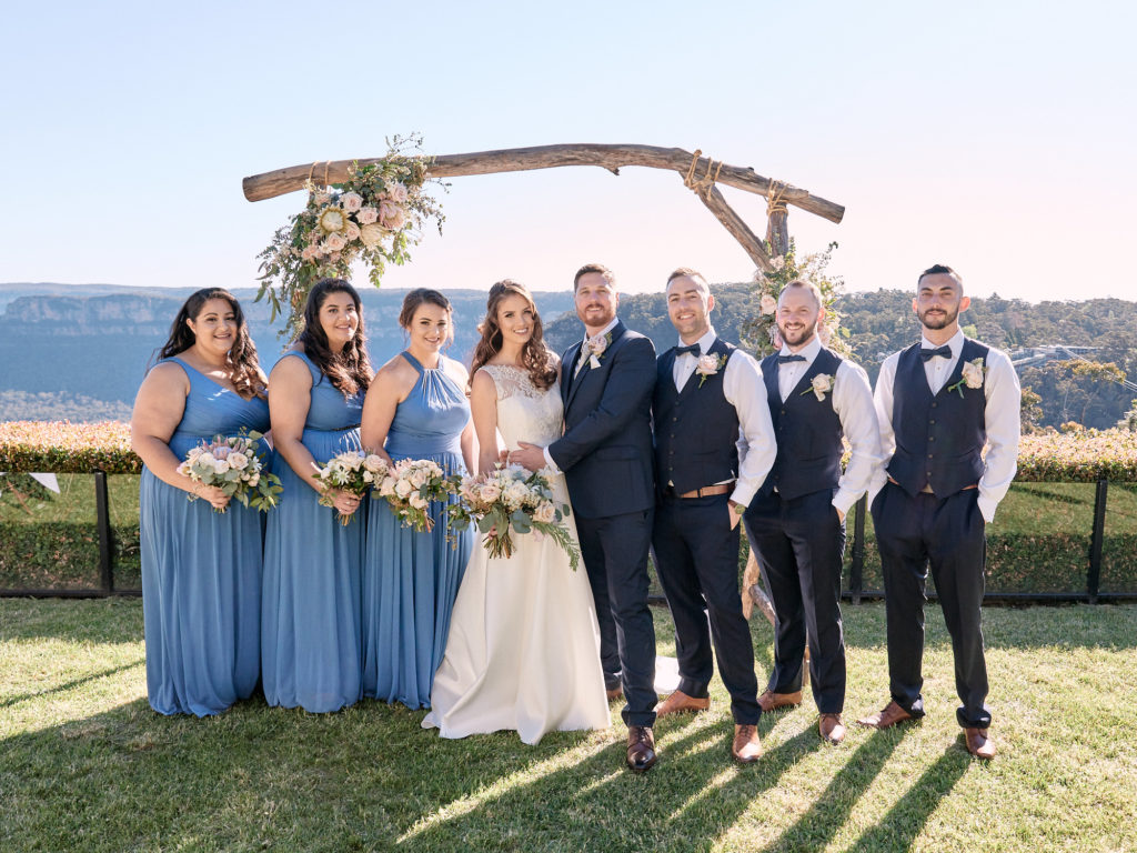 Bridal Party standing in front of arbour with a view of Narrowneck Plateau behind them